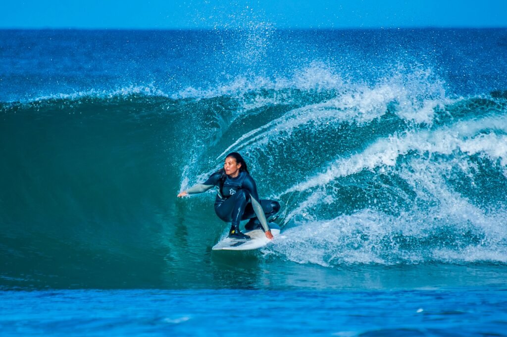 A woman skillfully surfs a large wave at Jeffreys Bay, South Africa.